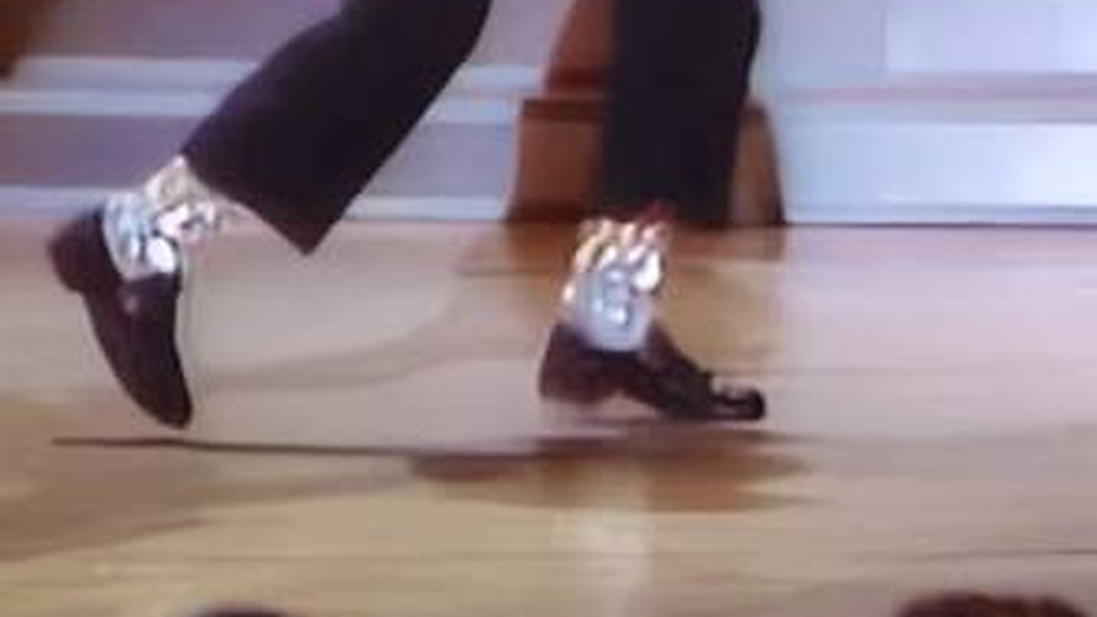 Michael Jackson mid-moonwalk during Billie Jean at Motown 25, gliding backward across the lit stage.